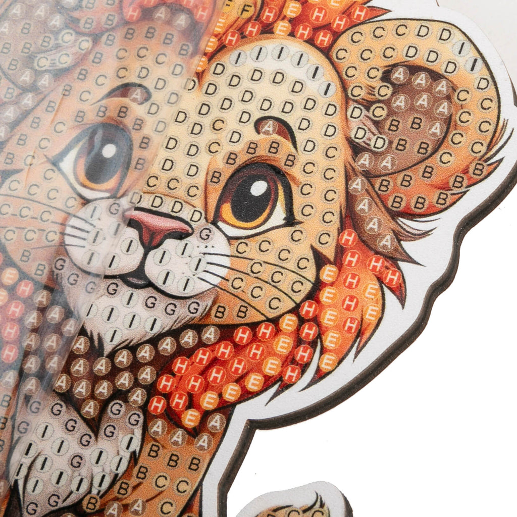 close up view of Lion Crystal Art Wildlife Buddy, showing adhesive template with coded spaces to show placement of crystals