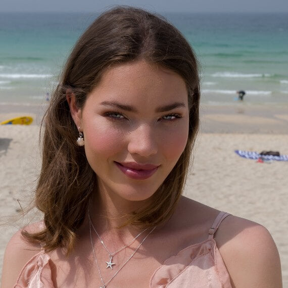 Model wearing Silver Origins Baby Scallop Shell Earrings plus Sparkling Starfish Pendant Necklace layered with Scallop Shell Pendant Necklace
