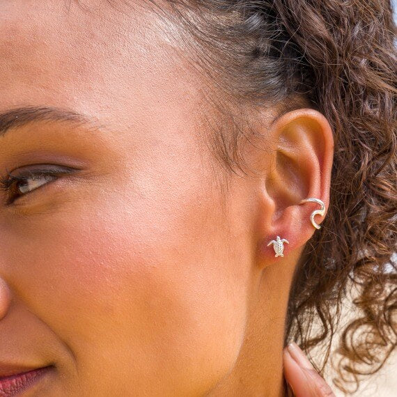 Model wearing Silver Origins Baby Tuttle Stud Earrings and Wave Cuff
