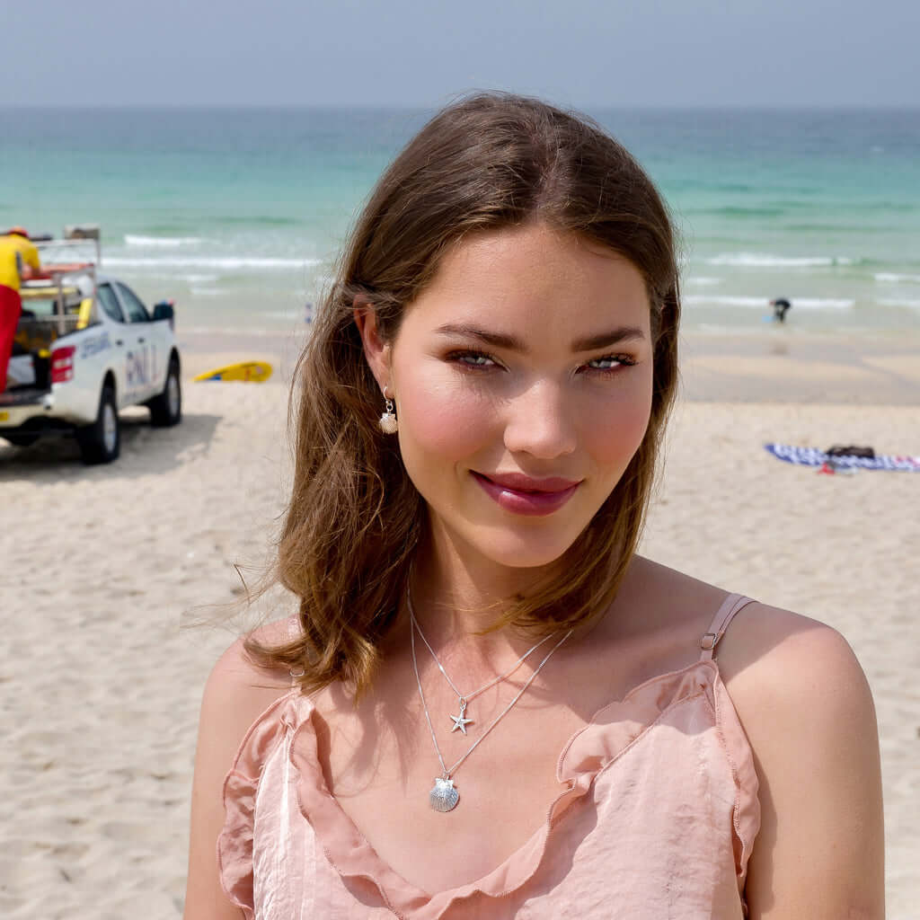 Model wearing three Silver Origins pieces, including sparkling starfish pendant necklace
